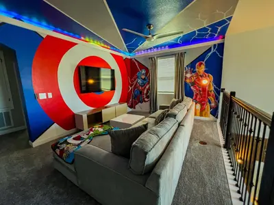 a living room with a couch and a captain america mural at 5BR Villa with Game Room and Spa, 12 Min to Disney in Kissimmee