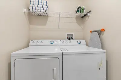 a small laundry room with a white washer at Amazing 5 Bedrooms4 BathsPool at Storey Lake Resort in Kissimmee