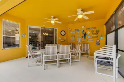 a dining room with yellow walls and a table and chairs at Large Pool Deck * All Rooms w/ Private Bathroom in Kissimmee