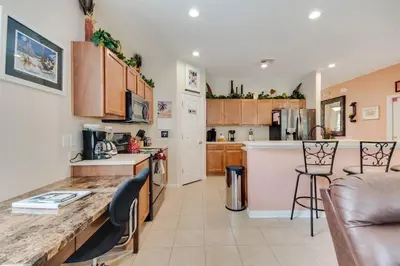 a kitchen and living room with a table and chairs at Large Pool Deck * All Rooms w/ Private Bathroom in Kissimmee