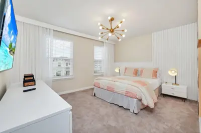 a white bedroom with a bed and a chandelier at Many Themes For Everyone 10 Huge Bedrooms! villa in Kissimmee