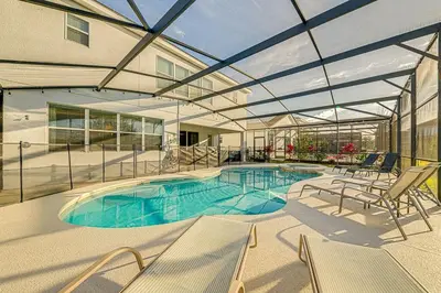 a swimming pool in a building with a glass ceiling at #371-Stunning 6 bed with modern decor, south facing pool and spa overlooking water in Kissimmee