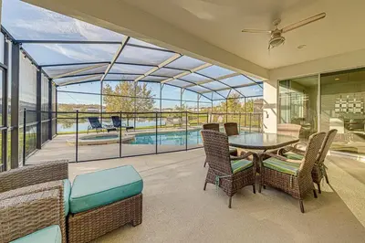 a conservatory with a table and chairs and a pool at #371-Stunning 6 bed with modern decor, south facing pool and spa overlooking water in Kissimmee