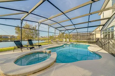 a swimming pool with a large glass roof at #371-Stunning 6 bed with modern decor, south facing pool and spa overlooking water in Kissimmee