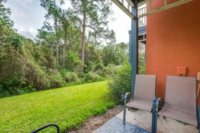 a porch with two chairs and a view of a yard at 2739SKP New Emerald Island 4 Bedroom townhouse in Kissimmee