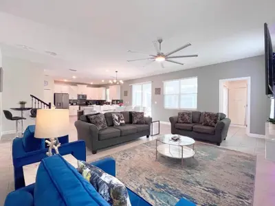 a living room with blue couches and a table at Eight-Bedroom House in Kissimmee