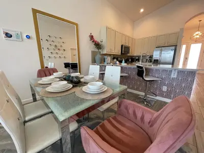 a kitchen and dining room with a table and chairs at #372-Welcome to Lightwater Villa, your Modern Disney Vacation home! South-Facing Pool & Spa Overlooking Lake in Kissimmee