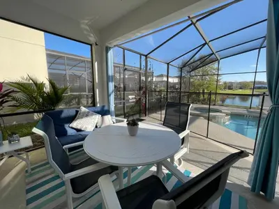 a balcony with a table and chairs and a pool at #372-Welcome to Lightwater Villa, your Modern Disney Vacation home! South-Facing Pool & Spa Overlooking Lake in Kissimmee