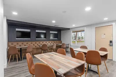 a meeting room with tables and chairs and a tv at Travelodge by Wyndham Kissimmee Orlando in Kissimmee