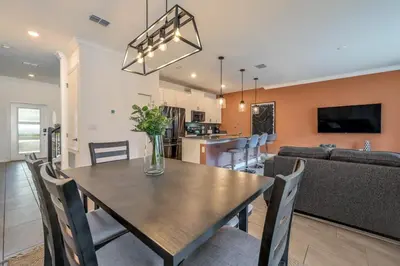 a dining room and living room with a table and chairs at Brand new home themed bedrooms prime location in Kissimmee