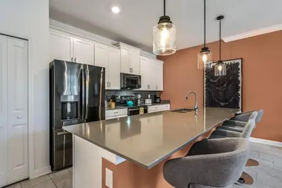 a kitchen with a large counter and a refrigerator at Brand new home themed bedrooms prime location in Kissimmee