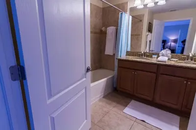 a bathroom with a tub and a sink and a door at Spacious 4 bed 3 bath Townhome with pool 5 STARS!! in Kissimmee