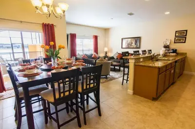 a kitchen and living room with a table and chairs at Spacious 4 bed 3 bath Townhome with pool 5 STARS!! in Kissimmee