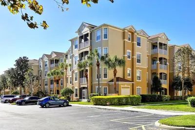 a row of apartment buildings with cars parked in a parking lot at Mickey's Hideaway Windsor Hills Resort in Orlando