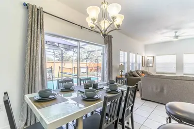 a dining room and living room with a table and chairs at 4552 Bella Vida 2 in Kissimmee
