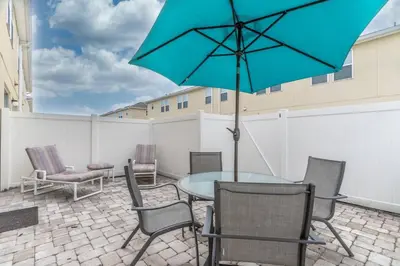 a patio with a table and chairs and an umbrella at 5134 Compass Bay in Kissimmee