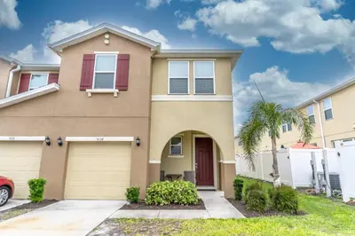 a house with a palm tree in front of it at 5134 Compass Bay in Kissimmee