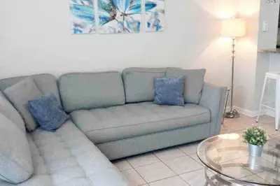 a living room with a couch and a glass table at Minutes to Disney, Free Water Park & Private Pool in Orlando
