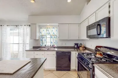 a kitchen with white cabinets and a stove top oven at Families with Pets! Home Near Orlando Theme Parks in Orlando