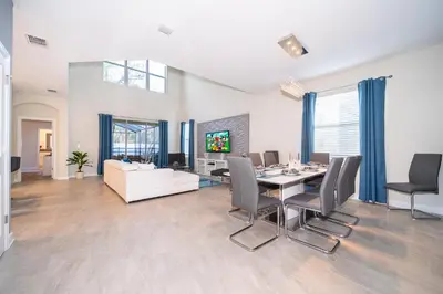 a dining room and living room with a table and chairs at Fabulous Villas 5 minutes away from Disney! in Kissimmee