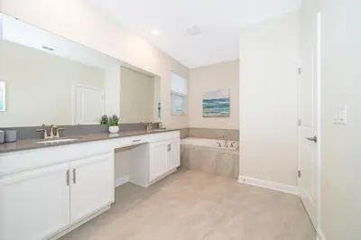 a white bathroom with two sinks and a tub at Fabulous Villas 5 minutes away from Disney! in Kissimmee