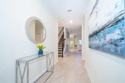 a hallway with a glass table and a large painting on the wall at Fabulous Villas 5 minutes away from Disney! in Kissimmee