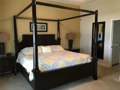 a bedroom with a large bed with a wooden frame at #472-Stunning 5 bed property with private south facing deck and pool in Orlando
