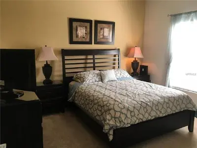 a bedroom with a bed and two lamps and a window at #472-Stunning 5 bed property with private south facing deck and pool in Orlando