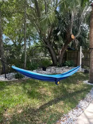 a blue hammock laying in the grass next to a tree at Private Villa/Outdoor Oasis in Kissimmee