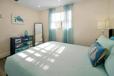 a bedroom with a large white bed and a dresser at Private Villa/Outdoor Oasis in Kissimmee