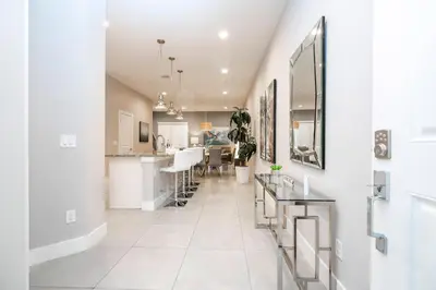 a kitchen and dining room with white walls and white tile floors at Gorgeous NEW 4 Beds Dream Villa 5 min to Disney in Orlando