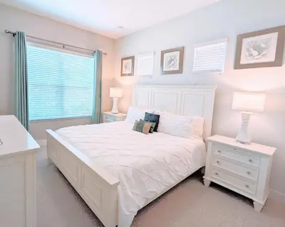 a white bedroom with a white bed and a window at 5 Suites DREAM House 5 min to Disney in Orlando