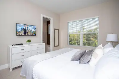 a white bedroom with a white bed and a window at Dreamscape NEW 4 Suites Villa 5 min to Disney in Orlando