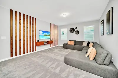 a living room with a couch and a tv at 10BR Resort Home - Pool Hot tub Games - Near Disney in Kissimmee