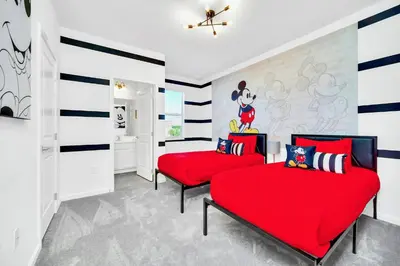two red beds in a room with striped walls at 10BR Resort Home - Pool Hot tub Games - Near Disney in Kissimmee