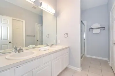 a bathroom with two sinks and a large mirror at Under The Sea Villa villa in Orlando