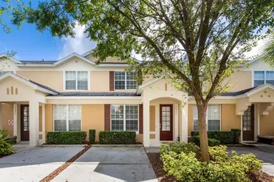 a house with a tree in front of it at Charming 3BR Townhome Private Pool Walk to Clubhouse 9 Min Disney in Orlando