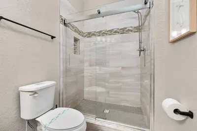 a bathroom with a toilet and a glass shower at Windsor Hills Dream - 3BR - 2 miles from Disney in Orlando