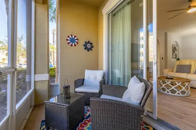 a porch with wicker chairs and a glass table at Windsor Hills Dream - 3BR - 2 miles from Disney in Orlando