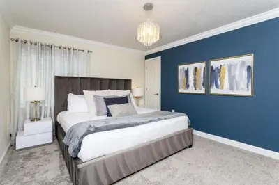a bedroom with a large bed with a blue wall at Amazing Villa 5BR Heated Pool Themed Rooms - 5 miles Disney in Kissimmee