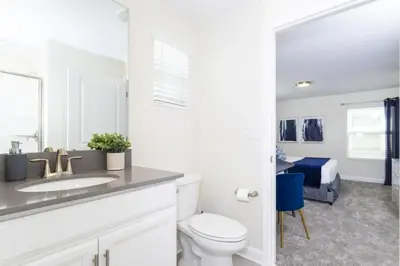 a bathroom with a sink and a toilet and a bedroom at Amazing Villa 5BR Heated Pool Themed Rooms - 5 miles Disney in Kissimmee