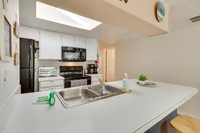 a kitchen with a sink and a stove top oven at Condo with Pool Access and Patio 8 Mi to Disney! in Kissimmee