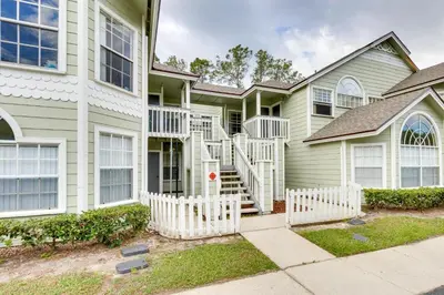 a house with a white fence in front of it at Condo with Pool Access and Patio 8 Mi to Disney! in Kissimmee