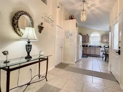 a kitchen with a refrigerator and a table with a lamp at Magic Orlando Villa, You are in Disney in Kissimmee