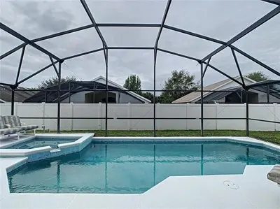 a large swimming pool with a fence around it at Magic Orlando Villa, You are in Disney in Kissimmee