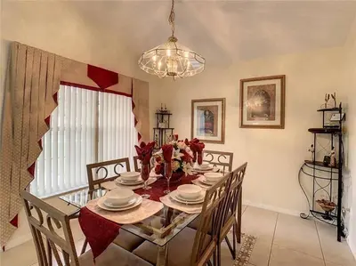 a dining room with a table with chairs and a chandelier at Magic Orlando Villa, You are in Disney in Kissimmee